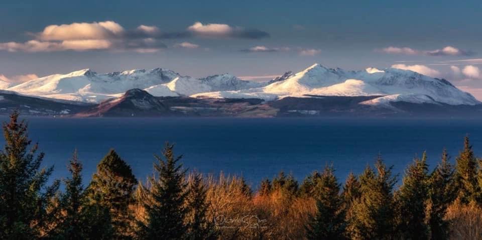 A photo of Arran showing snowy mountain tops -taken from the mainland.