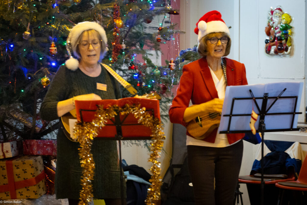 A photograph of musicians playing in front of the Christmas tree in Brodick hall